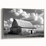 Framed canvas wall art showcasing a serene landscape with a rustic barn under a blue sky, elegantly bordered in silver, perfect for home decor.