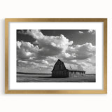 Framed wall art featuring a serene landscape of rustic barns, elegantly matting in gold, showcasing a harmonious blend of nature and architecture for home decor.