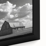 Framed wall art featuring a vibrant landscape of rustic barns nestled among rolling hills, showcasing rich greens and warm earth tones, perfect for home decor.