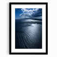 Framed wall art showcasing a vibrant beach landscape design, featuring soft blues and warm sandy tones, elegantly matted and presented in a sleek black frame.