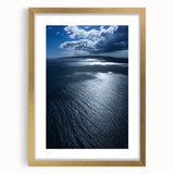 Framed wall art featuring a serene beach landscape with soft waves and golden sand, accented by a gold mat, ideal for home decor in coastal themes.