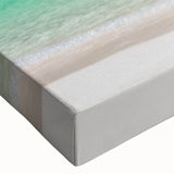 Close-up of a vibrant stretched canvas artwork showcasing a serene beach landscape with soft waves and a colorful sunset, perfect for home decor in coastal themes.