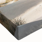 Colorful close-up of a stretched canvas depicting a serene beach landscape, showcasing vibrant blues and sandy tones, perfect for coastal home decor.