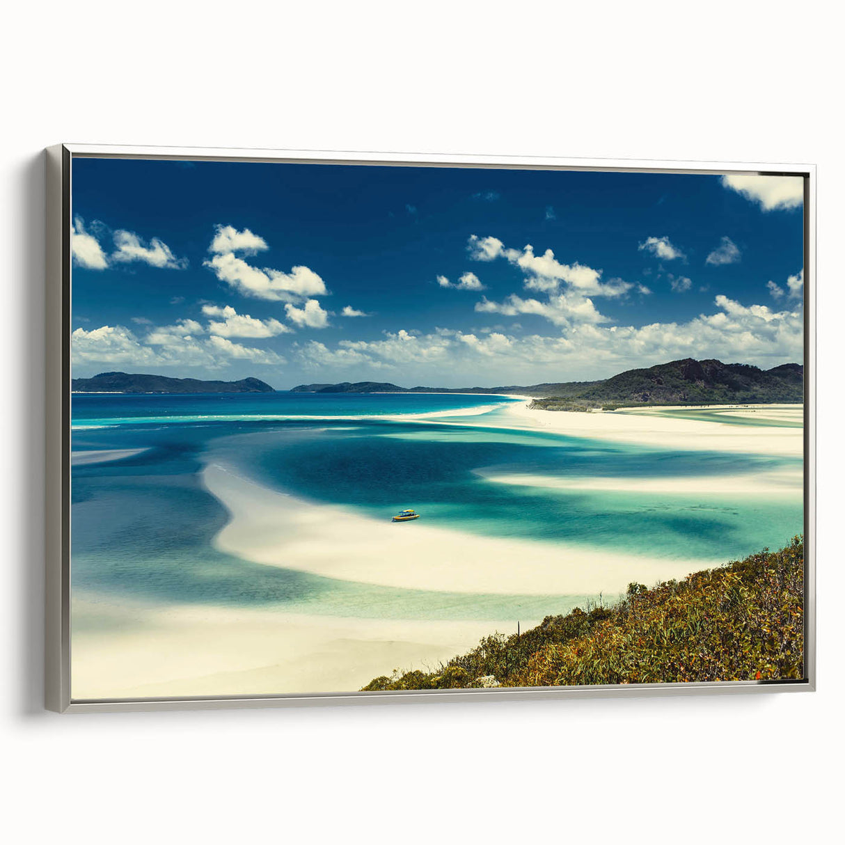 Framed canvas wall art showcasing a serene beach landscape, featuring soft blue and beige tones, with a sleek silver frame adding elegance to any decor. Perfect for enhancing living spaces with a calming coastal vibe.