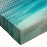 Close-up of a vibrant stretched canvas wall art piece showcasing a serene beach landscape, featuring soft waves, golden sand, and a clear blue sky, ideal for home decor.