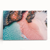 Stretched canvas wall art showcasing a serene beach landscape with vibrant blues and sandy tones, elegantly leaning against a neutral wall, perfect for home decor.