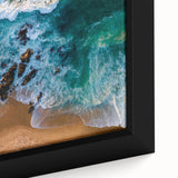 Close-up of a framed canvas wall art piece showcasing a vibrant beach landscape with turquoise waters and golden sand, perfect for home decor.