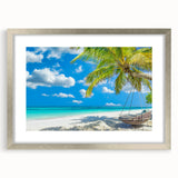 Framed wall art design featuring a serene beach landscape with calming blue and sandy tones, elegantly displayed in a silver frame with a white mat. Perfect for coastal-themed decor.