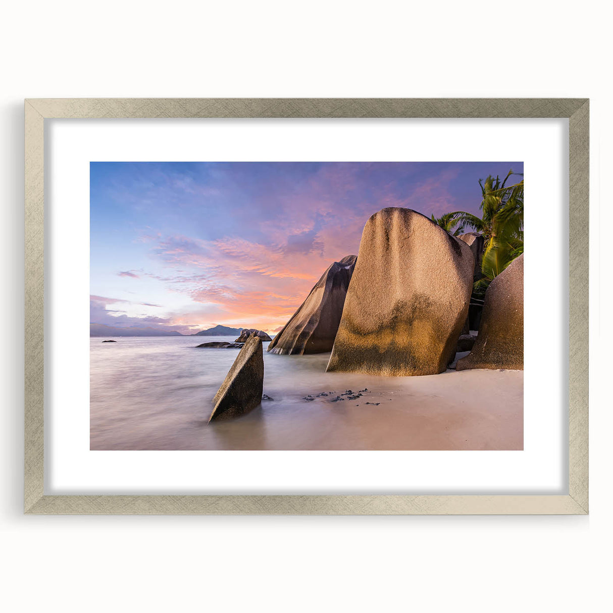 Framed wall art featuring a serene beach landscape with soft waves and a sunset sky, elegantly displayed in a silver frame with a white mat, perfect for coastal decor.