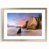 Framed wall art featuring a serene beach landscape with soft waves and a sunset sky, elegantly displayed in a silver frame with a white mat, perfect for coastal decor.