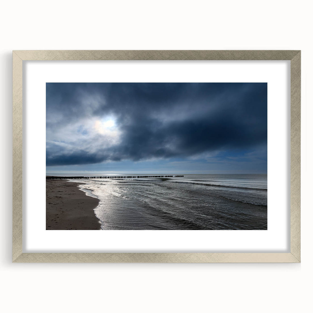 Framed wall art showcasing a serene beach landscape with soft waves and a colorful sunset, elegantly presented in a silver frame with a mat, perfect for home decor.