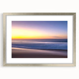 Framed silver wall art showcasing a serene beach landscape, featuring soft pastel colors and a white mat, perfect for enhancing coastal-themed decor.
