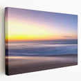 Stretched canvas artwork depicting a serene beach landscape with soft pastel colors, showcasing gentle waves and a tranquil sky, ideal for home decor.