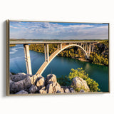 Framed canvas wall art featuring a serene landscape with a bridge, complemented by a gold frame, ideal for enhancing modern home decor. The design showcases lush greenery and a tranquil river, perfect for creating a calming atmosphere in living spaces.