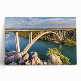 Stretched canvas art featuring a serene landscape with a bridge over a tranquil river, showcasing vibrant colors and intricate details, perfect for home decor.