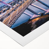Rolled canvas showcasing a vibrant landscape scene with a bridge at sunset, featuring rich colors and intricate details, ideal for home decor enhancement.