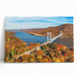 Stretched canvas wall art depicting a serene landscape featuring a bridge over a tranquil river, with lush greenery and vibrant blue skies, perfect for home decor.
