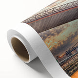 Rolled canvas artwork showcasing a serene landscape with a bridge, featuring vibrant colors and intricate details, ideal for home decor or office settings.