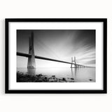 Framed wall art featuring a picturesque landscape with a bridge, presented in a sleek black frame and matting, ideal for enhancing home decor aesthetics.