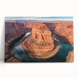 Stretched canvas wall art showcasing a stunning canyon landscape design with vibrant colors, leaning against a neutral-colored wall, perfect for home decor.