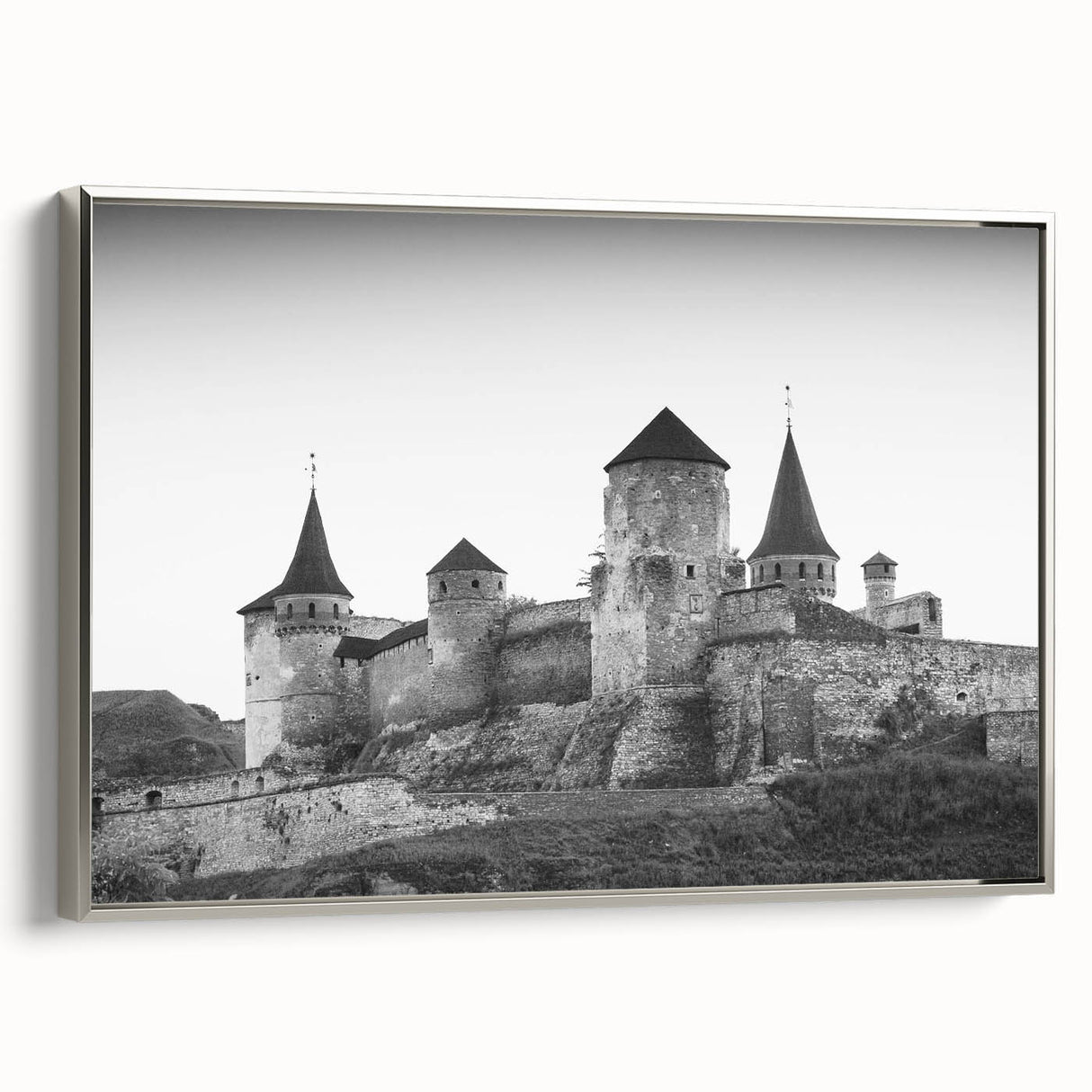 Framed canvas wall art showcasing a picturesque landscape featuring a majestic castle, presented in a sleek silver frame, ideal for enhancing home décor.