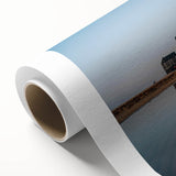 Rolled canvas artwork showcasing a stunning landscape featuring a majestic castle surrounded by vibrant greenery and a clear blue sky, perfect for home decor.