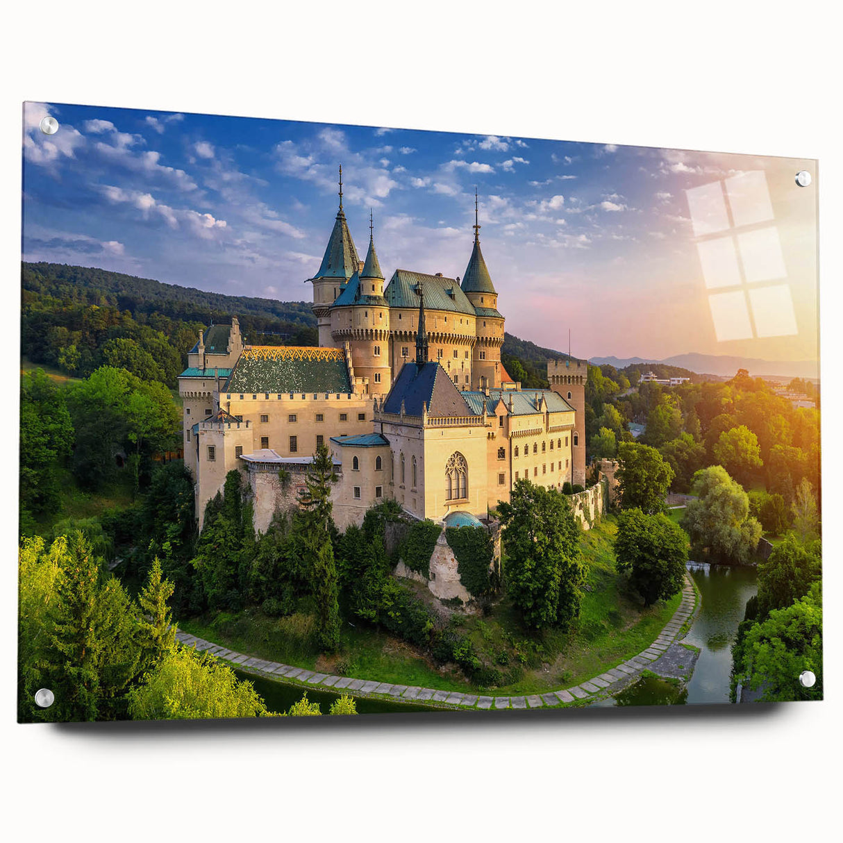 Acrylic glass wall art collection showcasing a detailed landscape of a castle, displayed in a modern setting with pins for hanging, emphasizing vibrant colors and intricate design.