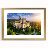 Framed wall art piece showcasing a picturesque landscape with a majestic castle, elegantly surrounded by a gold mat, perfect for home decor or office aesthetic.