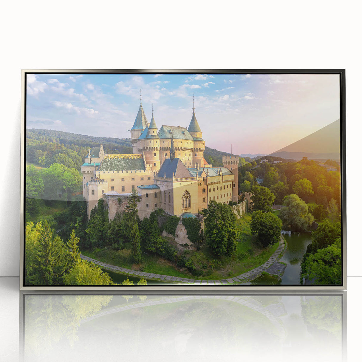 Framed wall art featuring a serene landscape with a majestic castle, set against a vibrant sunset. The acrylic surface enhances color depth, perfect for home decor.