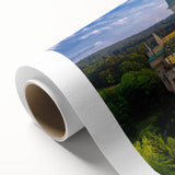 Rolled canvas artwork showcasing a stunning landscape of a castle surrounded by lush greenery, ideal for home decor, elegantly packaged in a protective tube.
