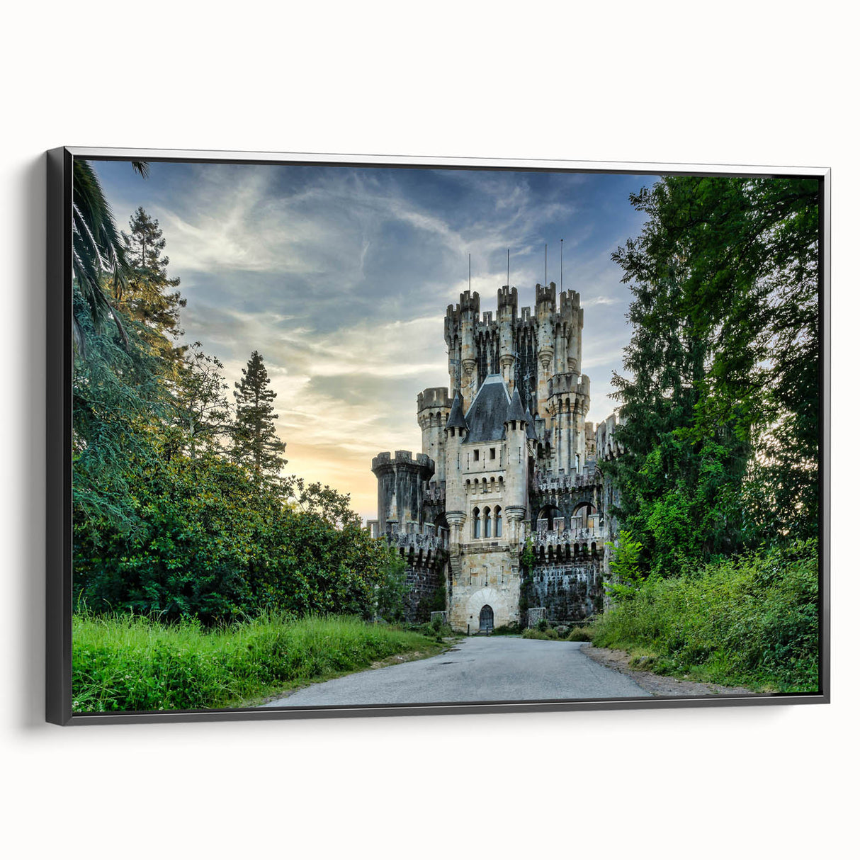 Framed canvas wall art featuring a picturesque landscape with a majestic castle, set against a serene background. The artwork has a sleek black frame, enhancing its elegance and charm, perfect for home decor enthusiasts.