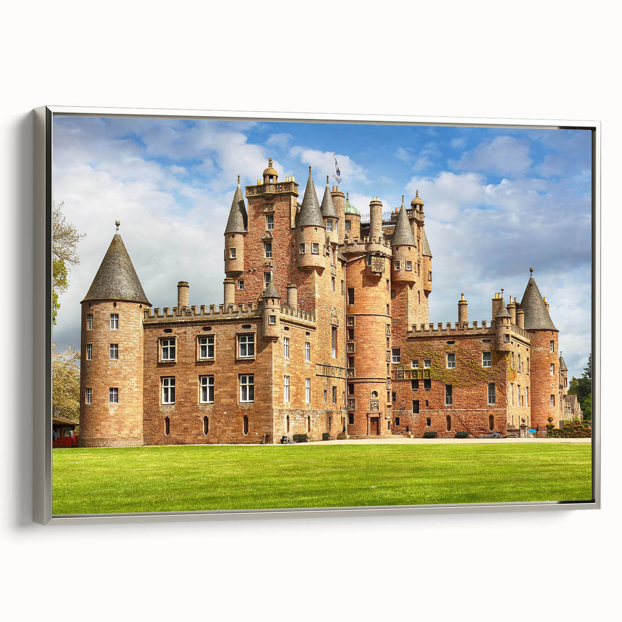 Framed canvas wall art featuring a stunning landscape of a castle surrounded by lush greenery, highlighted by a silver frame, perfect for enhancing home decor.