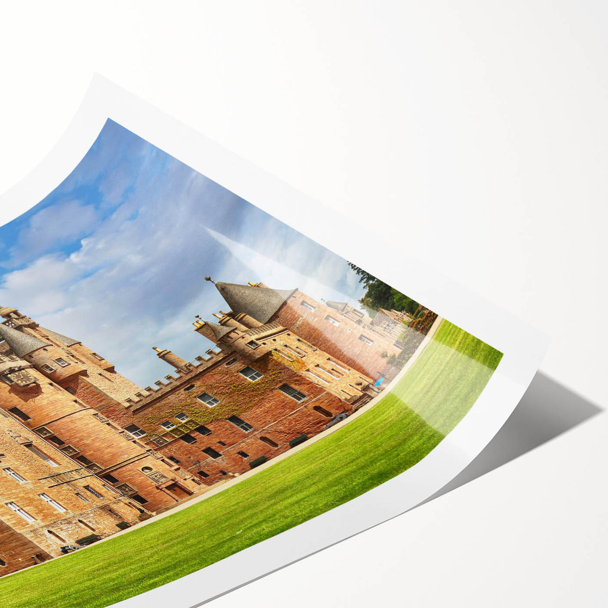 Rolled print of a vibrant landscape featuring a majestic castle surrounded by lush greenery, ideal for home decor; securely packaged in a protective cardboard tube.