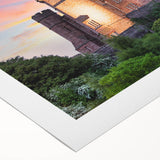Rolled canvas artwork showcasing a majestic castle landscape design, featuring lush greenery and a vibrant sunset, elegantly packaged in a protective cardboard tube.