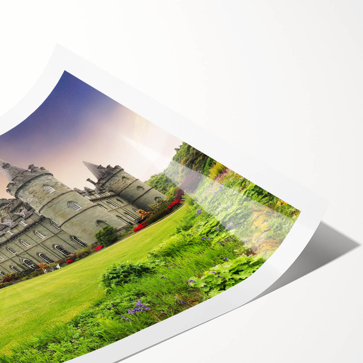 Rolled print showcasing a stunning landscape featuring a medieval castle surrounded by lush greenery and a clear blue sky, ideal for home decor enthusiasts.