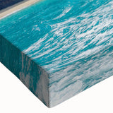 Close-up of a stretched canvas wall art featuring a dramatic landscape of cliffs and mountains, showcasing vibrant colors and intricate textures, ideal for home decor.