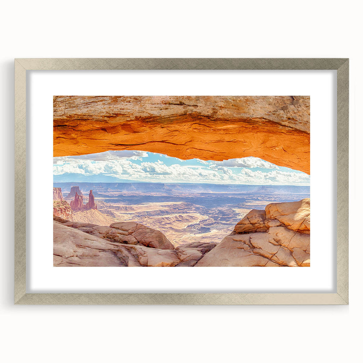 Framed wall art depicting a serene landscape of cliffs and mountains, featuring a silver mat and frame, ideal for enhancing home decor.