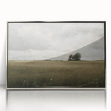 Framed wall art showcasing a serene countryside landscape with vibrant greens and a tranquil sky, elegantly displayed in a sleek silver frame, ideal for home decor.