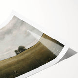 Rolling hills with vibrant green grass and a serene blue sky create a tranquil countryside landscape, perfect for home decor in a wall art collection. This print captures the beauty of nature, ideal for those seeking a peaceful ambiance in their living space.