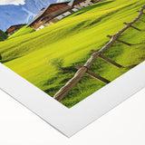 Rolled canvas wall art showcasing a vibrant countryside landscape with lush green fields and a serene sky, elegantly packaged in a protective cardboard tube.