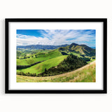 Framed black wall art showcasing a serene countryside landscape, featuring vibrant greenery and rolling hills, ideal for home decor and elegant interiors.