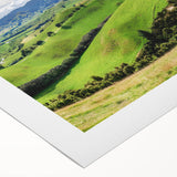 Serene countryside landscape wall art on rolled canvas, showcasing vibrant green fields, distant mountains, and a clear blue sky, perfect for home decor.