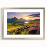 Framed wall art of a serene countryside landscape, featuring vibrant greens and soft blues, elegantly displayed in a silver frame with a white mat. Perfect for home decor.