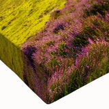 Close-up of a stretched canvas wall art piece depicting a serene countryside landscape, featuring vibrant greens and blues, perfect for home decor.