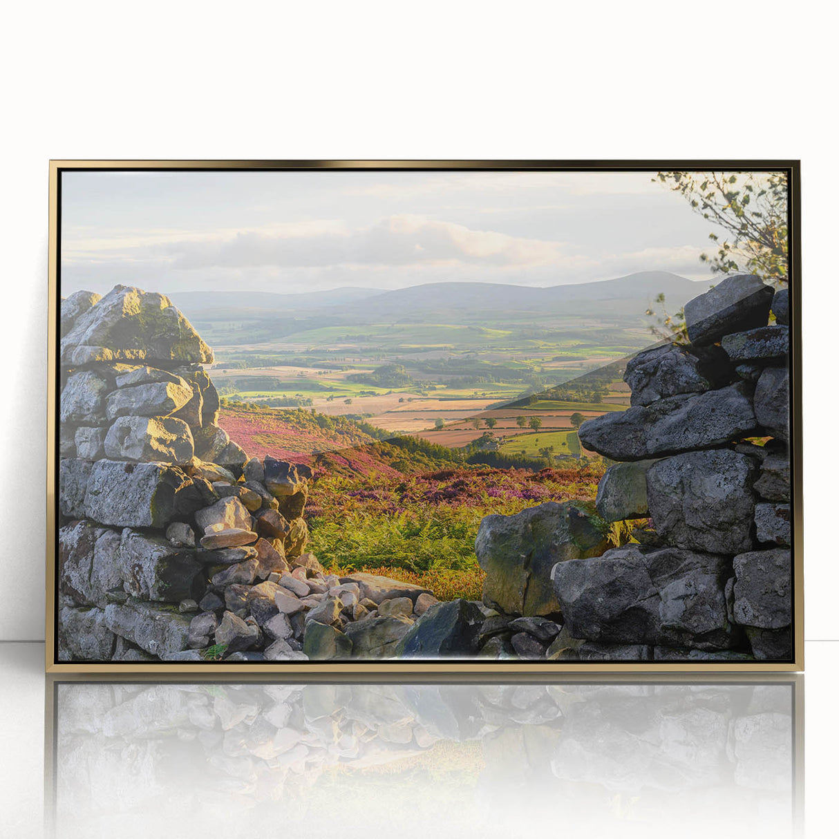 Framed acrylic wall art featuring a serene countryside landscape with lush green fields and a blue sky, highlighted by a sleek gold frame, perfect for home decor.