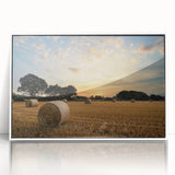 Framed wall art featuring a serene countryside landscape with lush green fields and a bright blue sky, designed for home decor in a modern white frame.