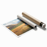 Rolled print showcasing a serene countryside landscape with vibrant green fields and a clear blue sky, perfect for home decor, presented in protective packaging.