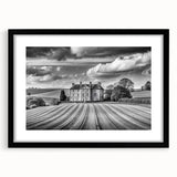 Framed wall art showcasing a serene countryside landscape with vibrant green fields and a striking blue sky. The black frame enhances the artwork's elegance, making it a perfect home decor piece.