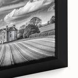 Close-up of a framed canvas artwork showcasing a serene countryside landscape, featuring lush green fields, rolling hills, and a vibrant sunset. Ideal for home decor.