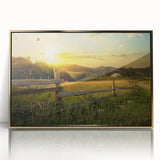 Framed acrylic wall art depicting a serene countryside landscape, featuring rolling hills and a vibrant sunset, elegantly showcased in a gold frame for a luxurious touch.